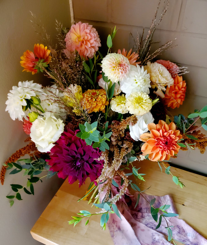 Rust orange, pink and ivory autumn October wedding bridal bouquet by District 2 Floral Studio using locally-grown flowers, tied with long flower-dyed silk fabric. 