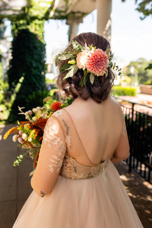 Bride holding her wedding bridal bouquet with a dahlia and eucalyptus floral hairpiece created by District 2 Floral Studio.