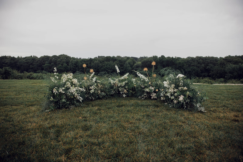 Outdoor wedding ceremony grounded meadow created by District 2 Floral Studio with locally grown Nebraska flowers.