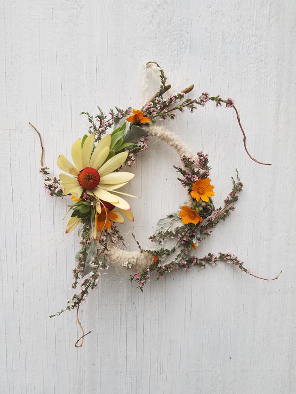 Wild curly willow, asymmetrical wreath with yellows and golden created by District 2 Floral Studio.