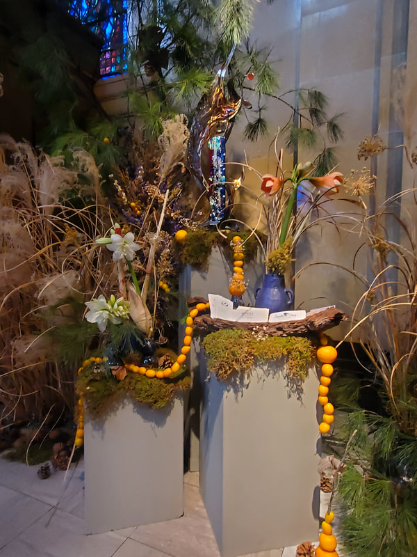 Seasonal winter floral installation by District 2 Floral Studio at a Cathedral with locally grown Nebraska evergreens, grasses, dried flowers, amaryllis and clementines.