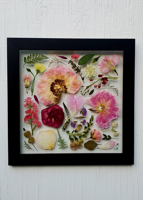 Pink pressed flower preservation piece by District 2 Floral Studio in a custom black frame.