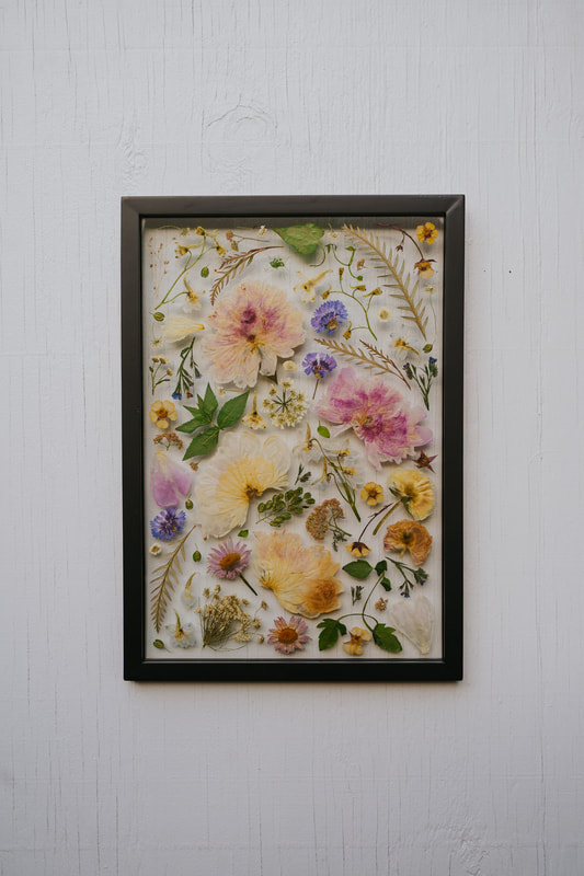 Pressed flower preservation piece by District 2 Floral Studio in a custom black frame.