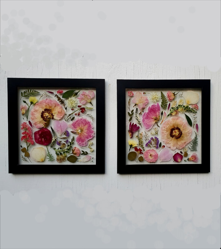 Two pressed flower preservation pieces by District 2 Floral Studio hanging side by side in custom black frames.