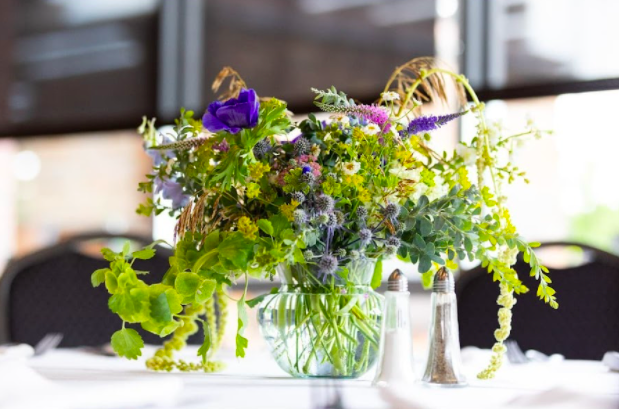 Centerpiece flower arrangement by District 2 Floral Studio created with locally grown flowers on a reception table.
