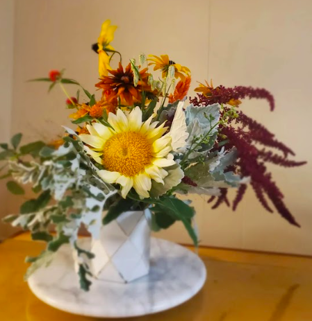 Sunflower and rudbeckia flower arrangement by District 2 Floral Studio created with locally grown flowers in a white vase.