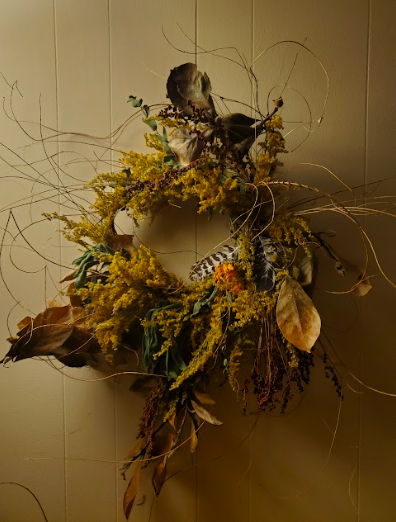 Wreath created by District 2 Floral Studio with locally grown Nebraska dried flowers, feathers and handwoven stems.